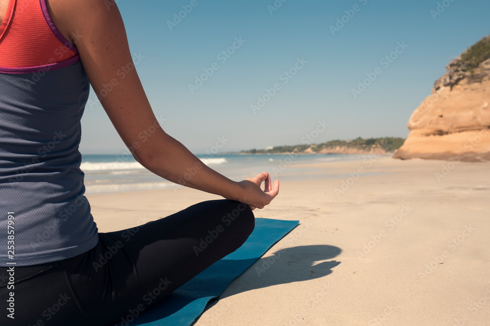 Close-up of young woman exercising yoga at a beach Close-up of young woman exercising yoga at a beach
