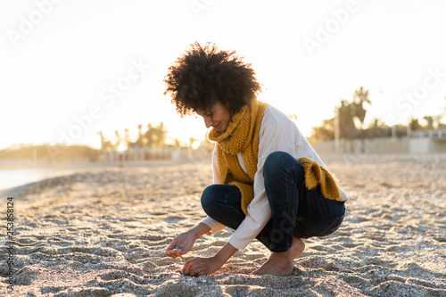 Woman collecting seashells on the beach