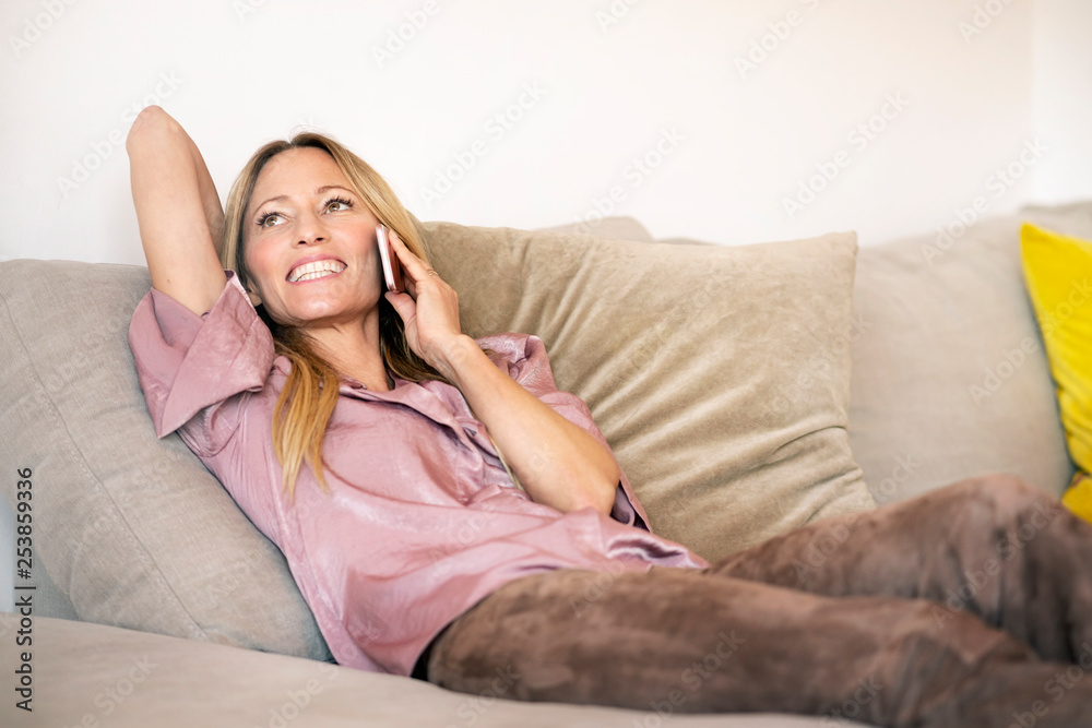 Portrait of woman on the phone relaxing on the couch at home Portrait of woman on the phone relaxing on the couch at home