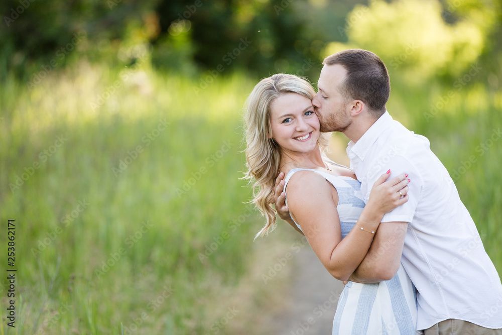 Young man kissing his pretty girlfriend on the cheek Young man kissing his pretty girlfriend on the cheek
