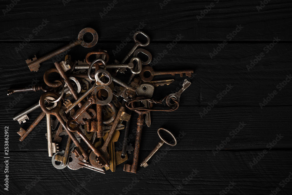 Bunch of old metal keys on a table, top view, low key. Theme of collecting, vintage decoration, safety concept Bunch of old metal keys on a table, top view, low key. Theme of collecting, vintage decoration, safety concept