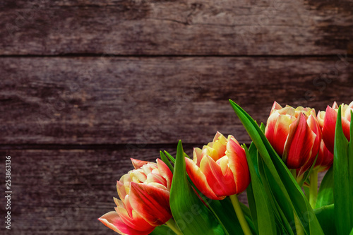 Spring flowers. Bouquet of Red and Orange tulips on brown wooden background. Mother's Day and Valentines Day background