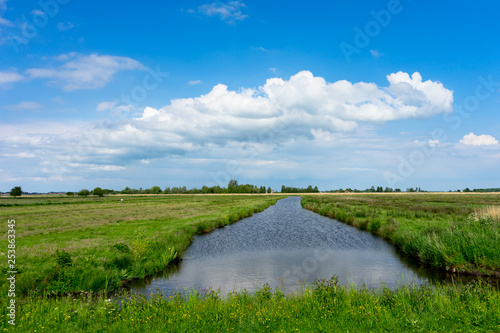 Photo Netherlands, Zaanse Schans, a close up of a lush green field next to a canal