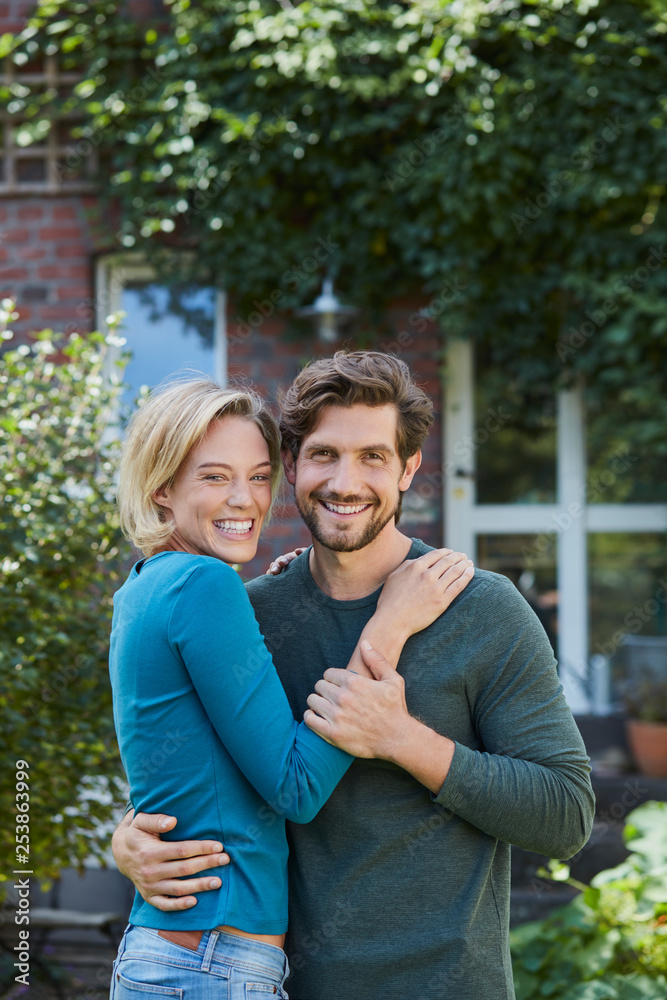 Portrait of happy couple in garden of their home
