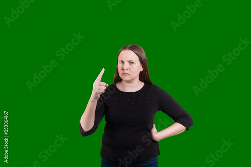 Fotografie Women on green screen pointing finger in reprimending serious look on her face