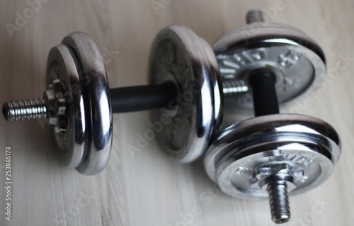 two iron dumbbells on a wooden background
