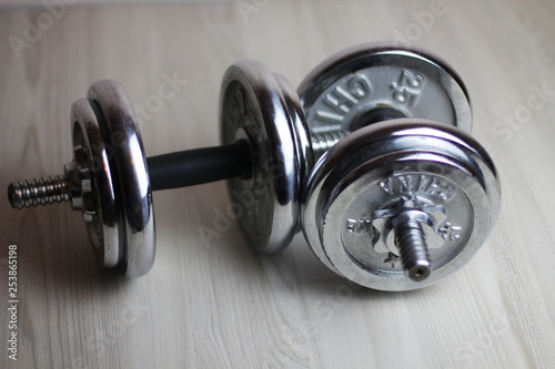 two iron dumbbells on a wooden background
