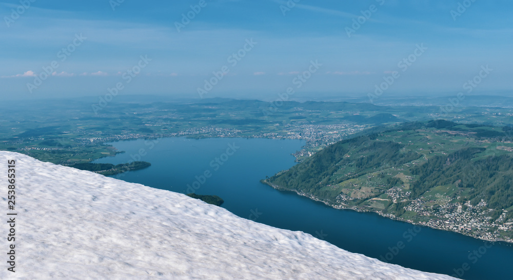 Beautiful spring panoramic view of snow-capped mountains in the Swiss Alps. Lake Zug in the background