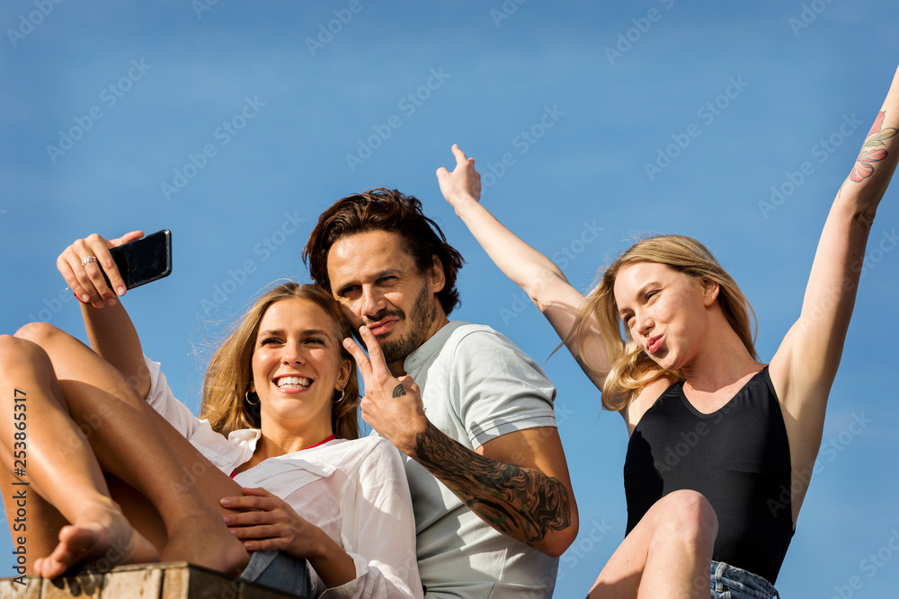 Friends having fun on a rooftop terrace, taking selfies Friends having fun on a rooftop terrace, taking selfies