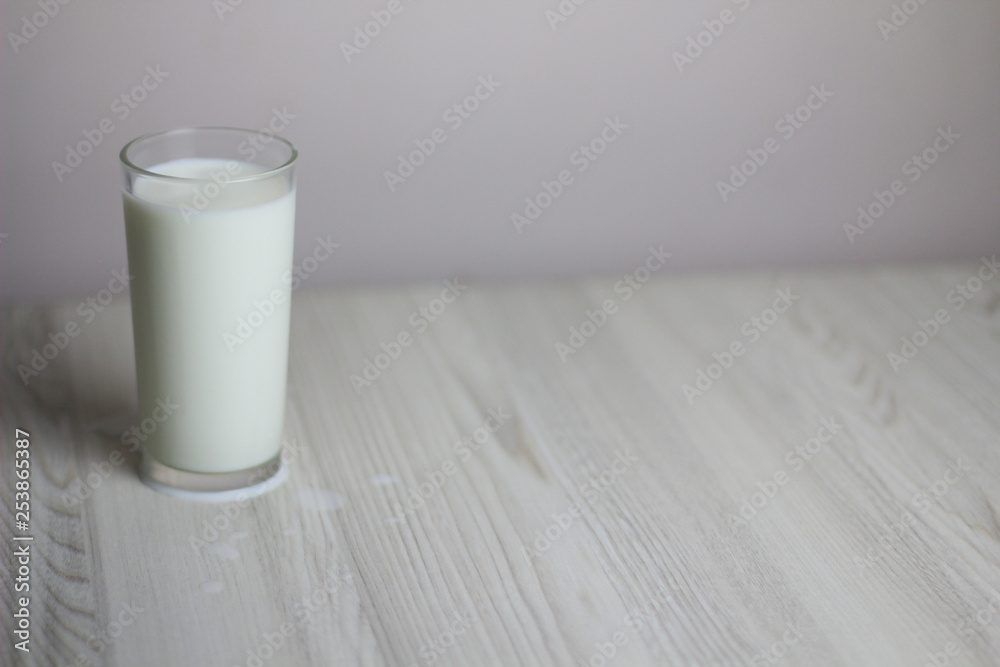 Glass with milk on the light wooden table Glass with milk on the light wooden table