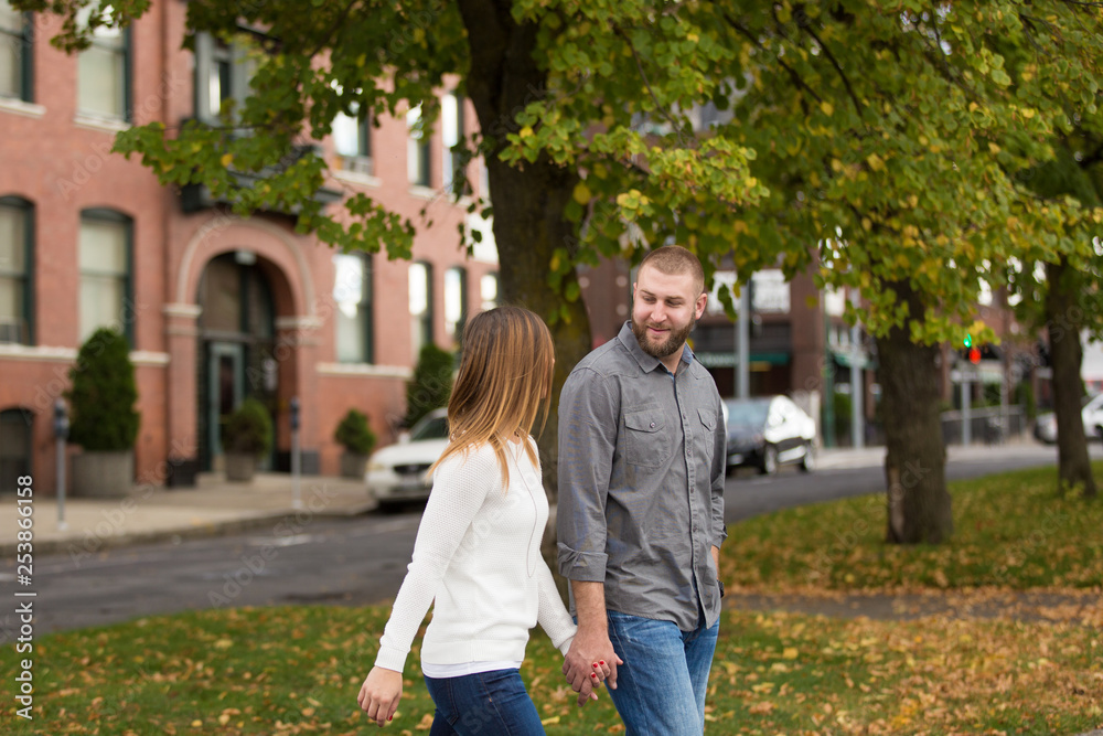 young attractive couple walking and holding hands young attractive couple walking and holding hands