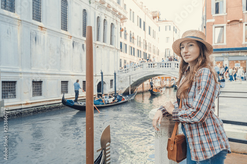 Woman waiting for gondolas near canal in Venice