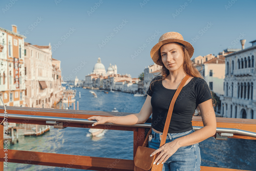 Woman in the Venice, standing on the bridge over the grand canal while on sightseeing in a foreign city. Discovery the Venice adventure.