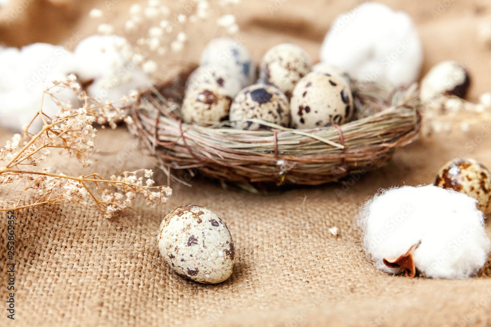 Easter decoration with egg in nest and cotton on brown rustic linen canvas background. Easter concept. Flat lay top view copy space. Spring greeting card Easter decoration with egg in nest and cotton on brown rustic linen canvas background. Easter concept. Flat lay top view copy space. Spring greeting card