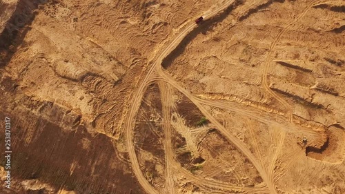 View of the large red truck in desert moving on a sandy track. Desert trip. photo