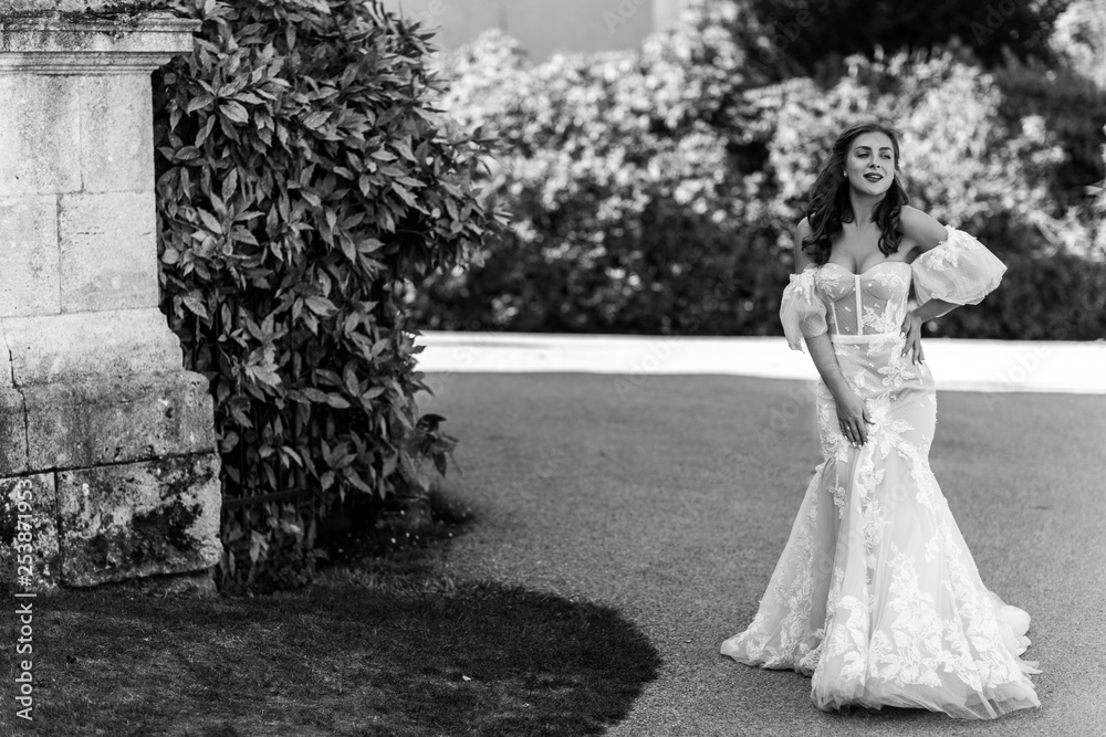 Black and white photo of an awesome bride who smiles and poses in luxury white dress on her happy wedding day Black and white photo of an awesome bride who smiles and poses in luxury white dress on her happy wedding day