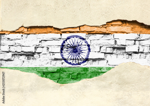 National flag of India on a brick background. Brick wall with partially destroyed plaster, background or texture.