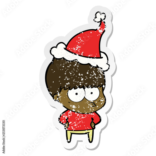 nervous distressed sticker cartoon of a boy wearing santa hat