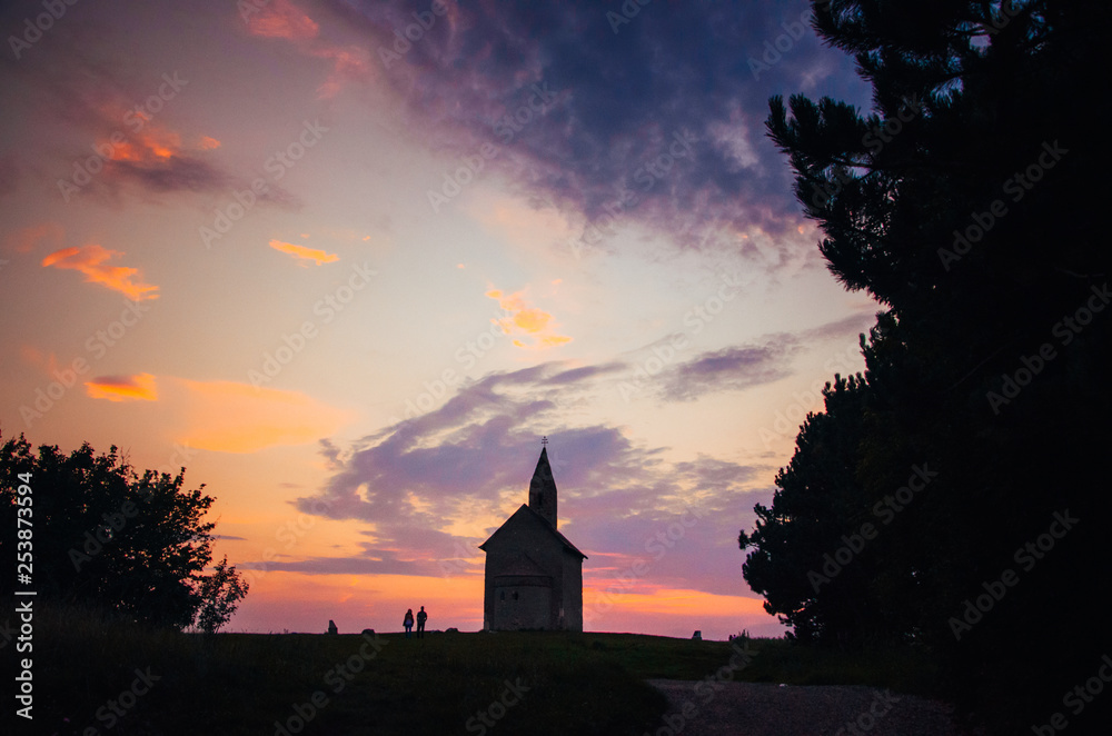Christianity church in summer evening. Dark silhouette, edit space, orange sunset light