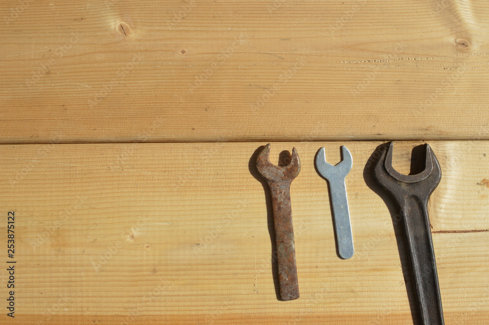 Family of wrench tools on wooden background. Close up top side view mockup design production details. Rusty and new generation industrial instrument. Family of wrench tools on wooden background. Close up top side view mockup design production details. Rusty and new generation industrial instrument.