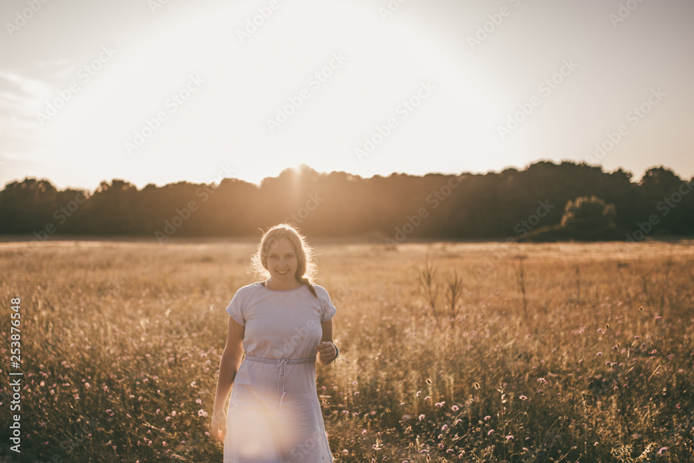 Frau genießt den Sommer beim Spaziergang durch ein Feld