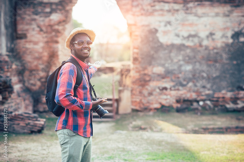 African tourist traveling in Thailand famous Temple Ayutthaya with holding camera