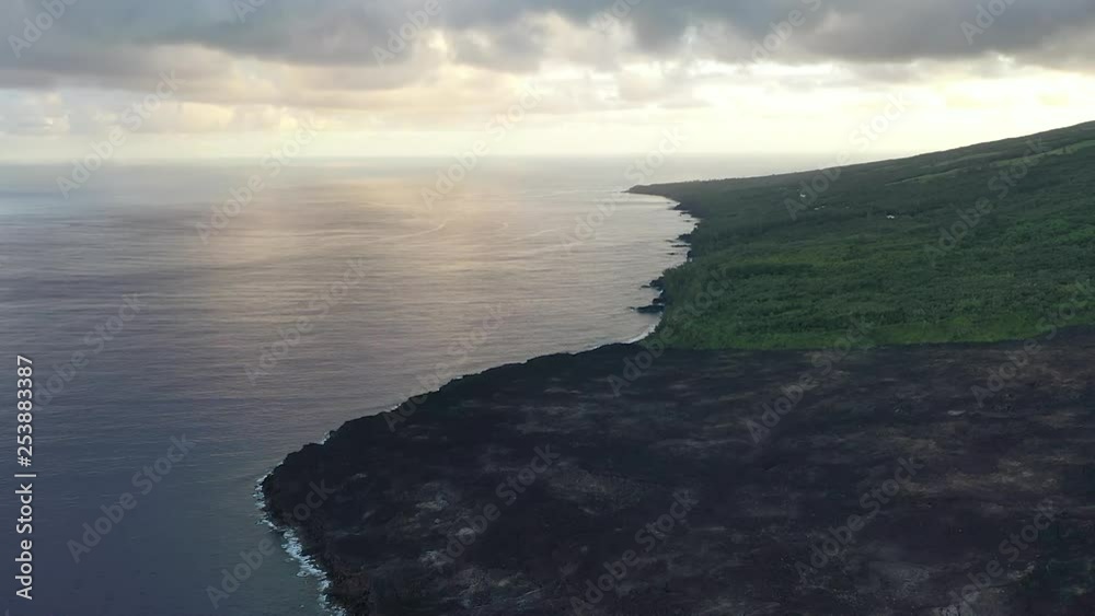 Aerial flight over the dried lava flow into the ocean from a volcanic eruption on Reunion Island Aerial flight over the dried lava flow into the ocean from a volcanic eruption on Reunion Island