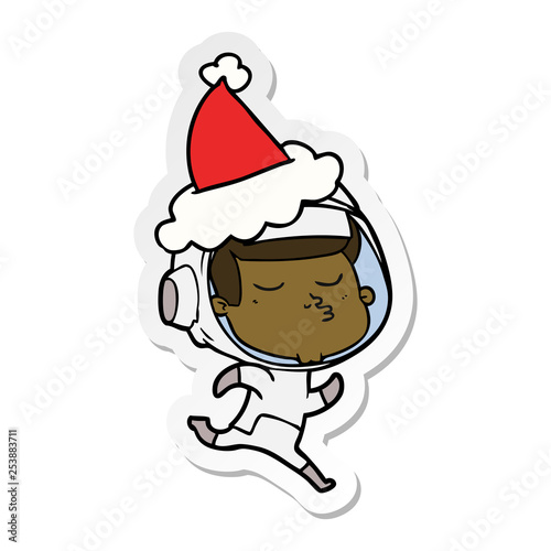sticker cartoon of a confident astronaut wearing santa hat