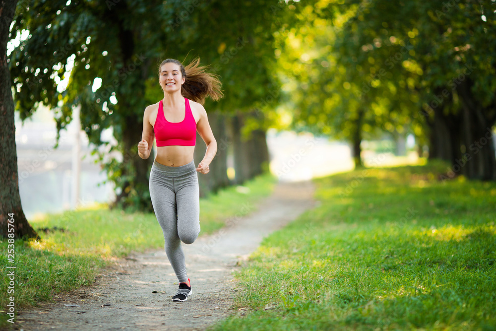 Young fitness woman running around in the park. Young fitness woman running around in the park.
