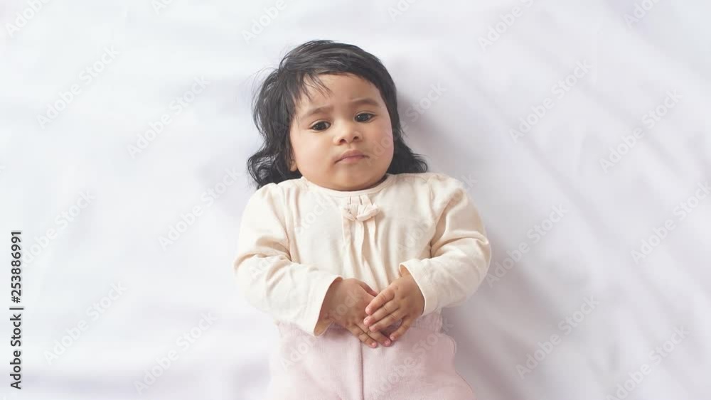 Little funny baby girl lifting body lying on white blanket. Little funny baby girl lifting body lying on white blanket.
