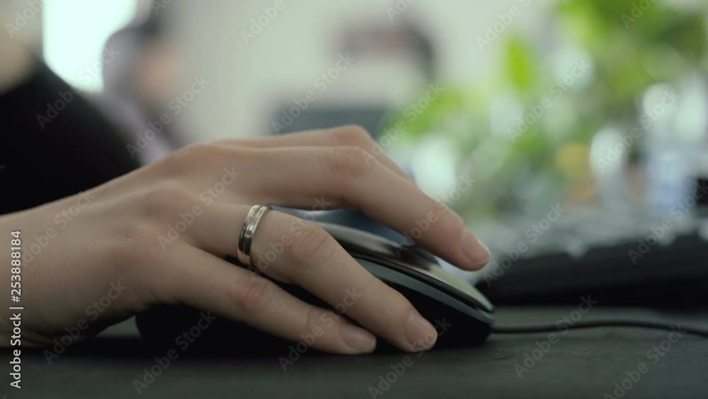 Hand using a mouse on a desk in an office, selective focus scrolling and clicking Hand using a mouse on a desk in an office, selective focus scrolling and clicking