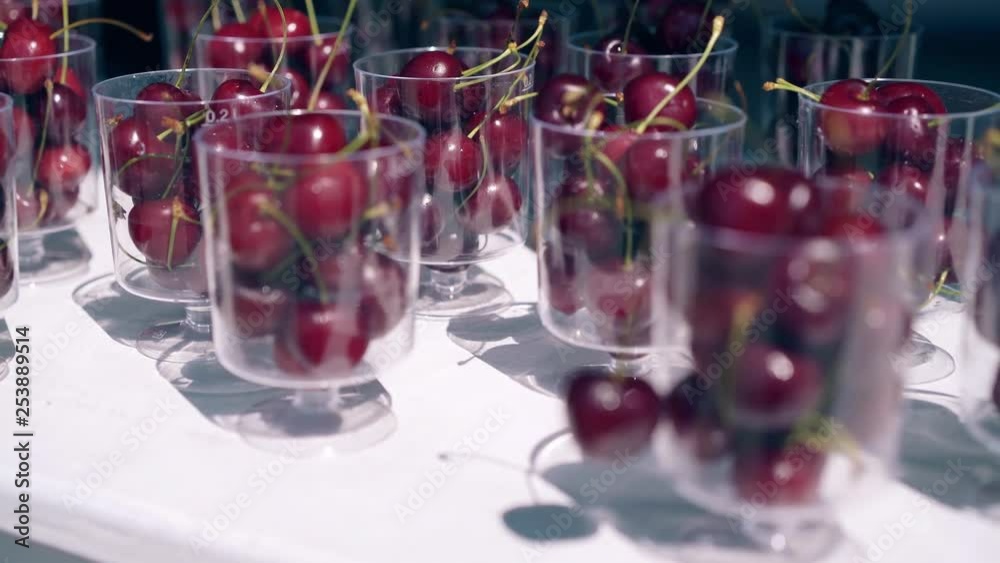 CU, Travelling around, 4k: Fresh cherries in transparent glasses on the table, on the beach in summer. CU, Travelling around, 4k: Fresh cherries in transparent glasses on the table, on the beach in summer.
