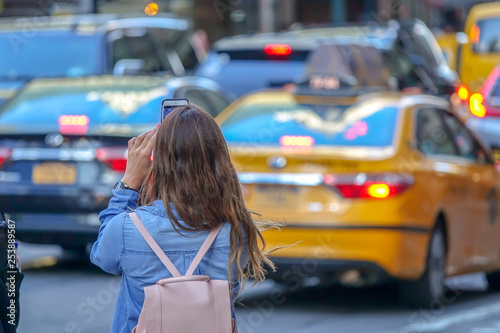 Tourist young girl taking a picture with her cell phone in Downtown New York