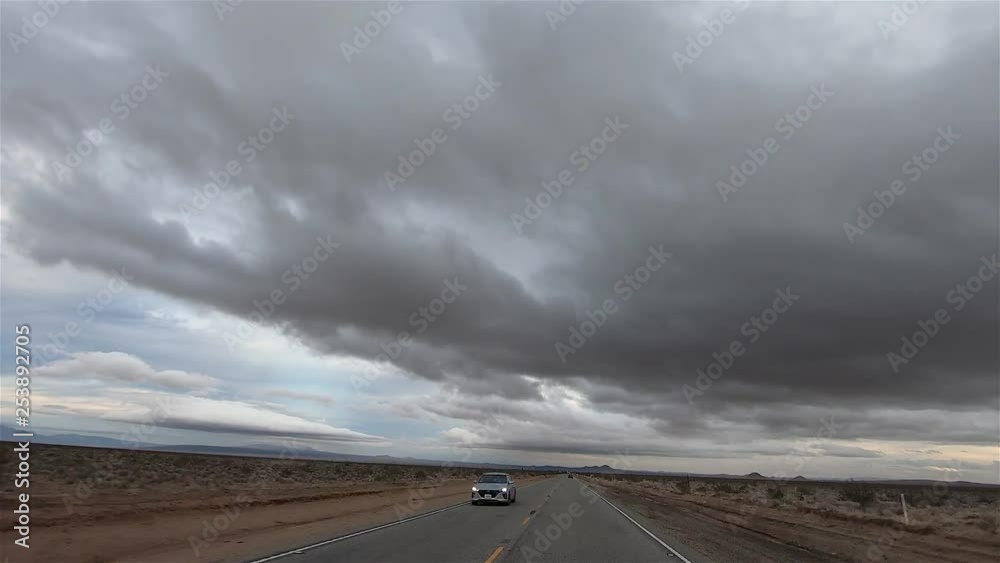 Hyperlapse, Driving through road in Mojave Desert with storm clouds above