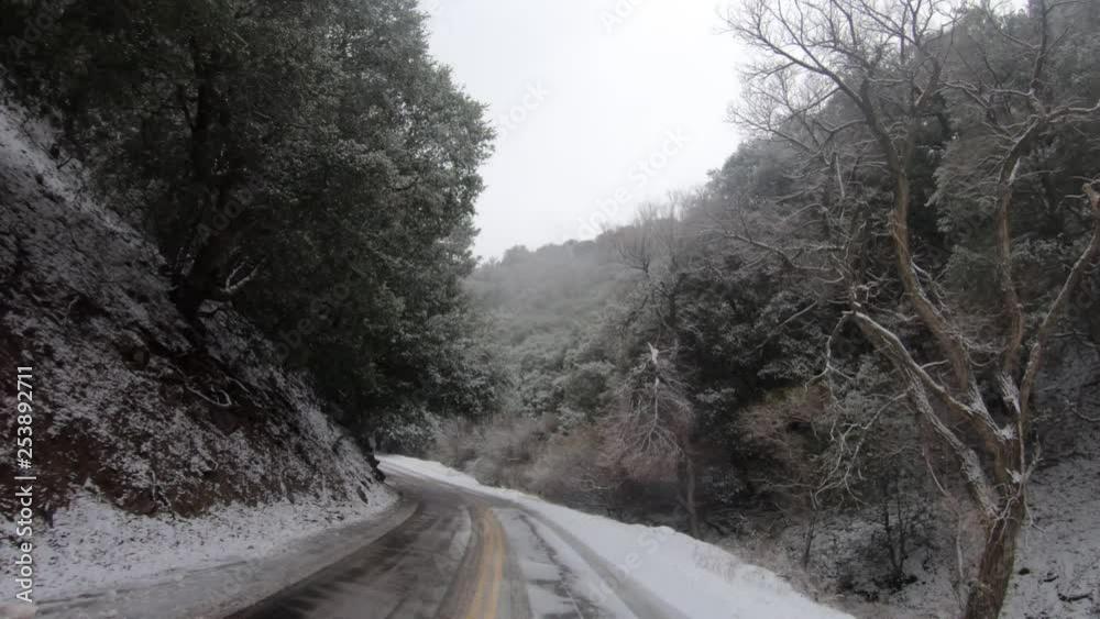 POV Driving in winter through winding road with snow falling POV Driving in winter through winding road with snow falling