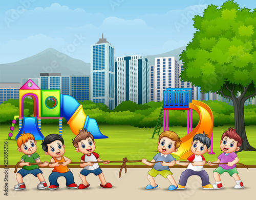 Happy Children playing tug of war in the city park