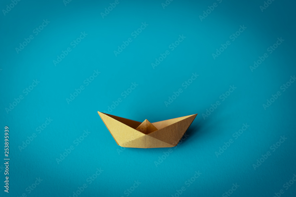 yellow paper boat on bright background with copy space, learning and education concept yellow paper boat on bright background with copy space, learning and education concept