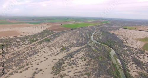 High aerial panning shot of US/Mexico border near Yuma, AZ. Begins with shot looking south and panning to the north.