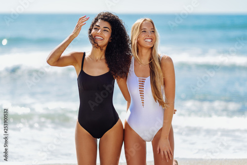 Fotografia Two young women with beautiful bodies in swimsuit on a tropical beach