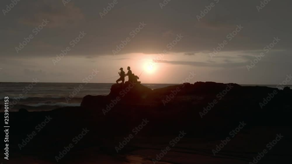 Aerial shot of an epic beach sunset showing waves, sand and fishing men in Bali, Indonesia. Aerial shot of an epic beach sunset showing waves, sand and fishing men in Bali, Indonesia.