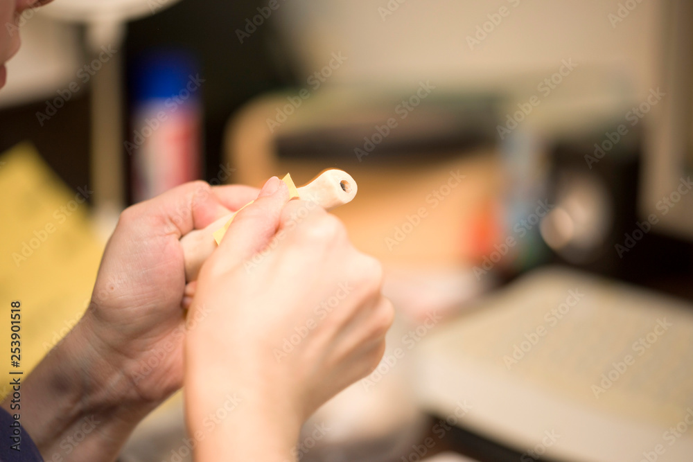Obraz premium Girl hands polishing parts for making dolls from polymeric material.