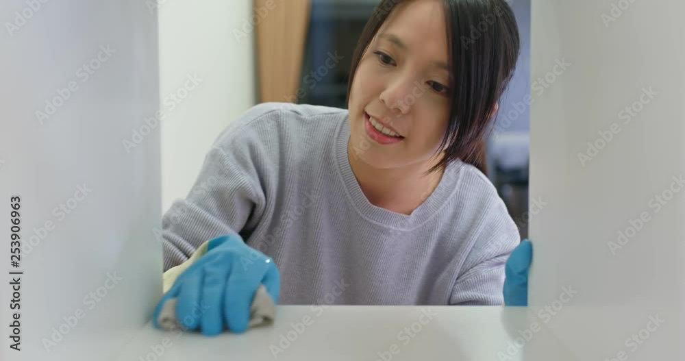 Woman clean the cabinet at home Woman clean the cabinet at home