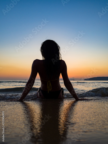 Silhouette of a woman on the beach at sunset