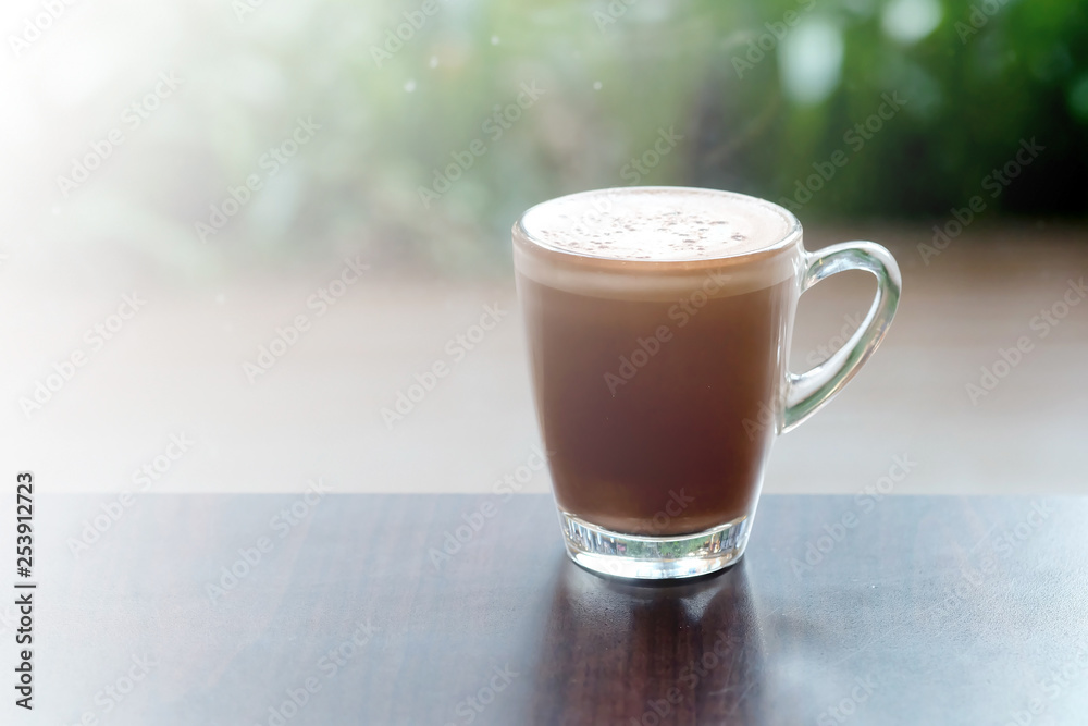 Hot chocolate or cocoa in clear glass cup on wood table in a restaurant with space for write wording, delicious antioxidant rich beverage that contain many health useful or health benefit for everyone Hot chocolate or cocoa in clear glass cup on wood table in a restaurant with space for write wording, delicious antioxidant rich beverage that contain many health useful or health benefit for everyone