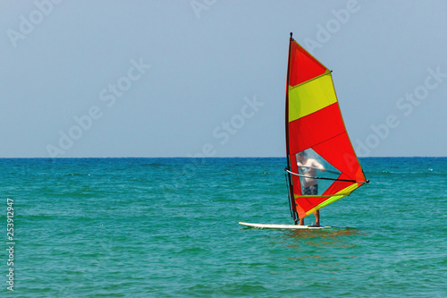 Windsurfing on the background of the sea landscape and clear sky. Windsurfer male go in for sports, copy space
