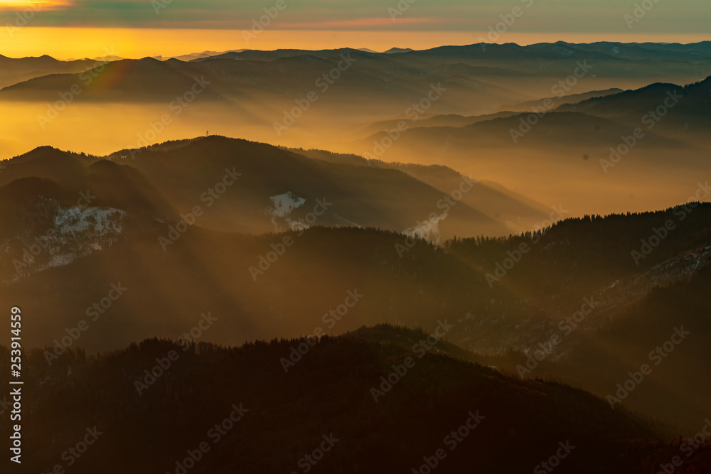 Mountain landscape with winter fog at sunse of Ceahlau, Romaniat