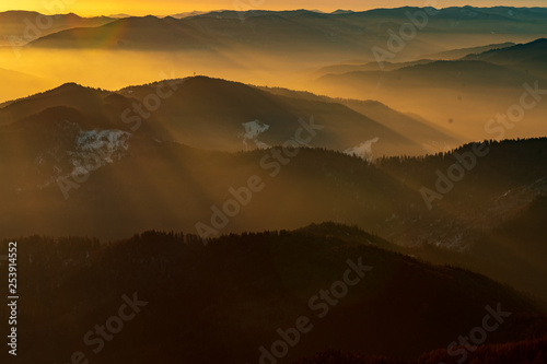 Mountain landscape with winter fog at sunse of Ceahlau, Romaniat