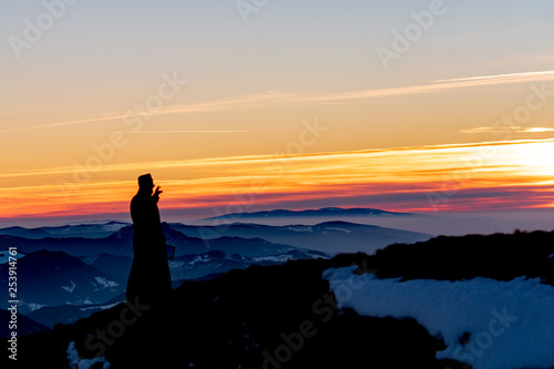 Priest silhoute reading in the sunset light, Romania