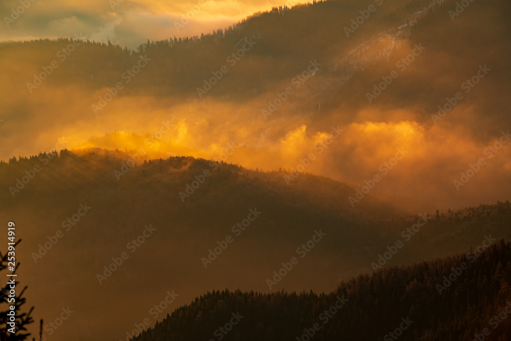 Naklejka premium Mountain landscape with winter fog at sunse of Ceahlau, Romaniat