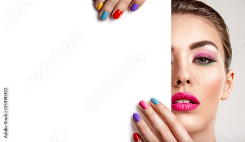 Beautiful  woman with a colored manicure holds blank poster. photo